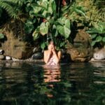 woman in lake covering face with hands