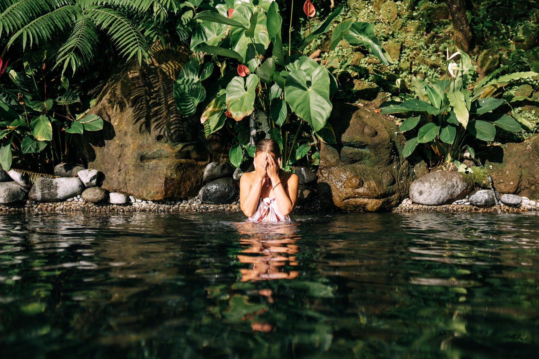 woman in lake covering face with hands