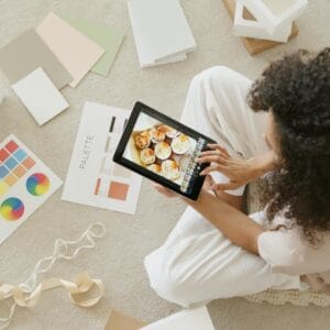 woman in white shirt holding black tablet computer
