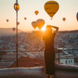 woman holding yellow balloons during sunset